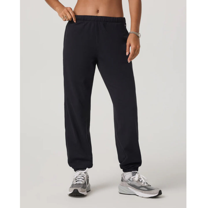 Person wearing black sweatpants on a light gray background