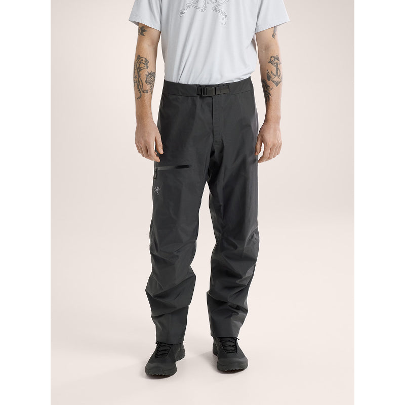 Person wearing black pants on a beige background