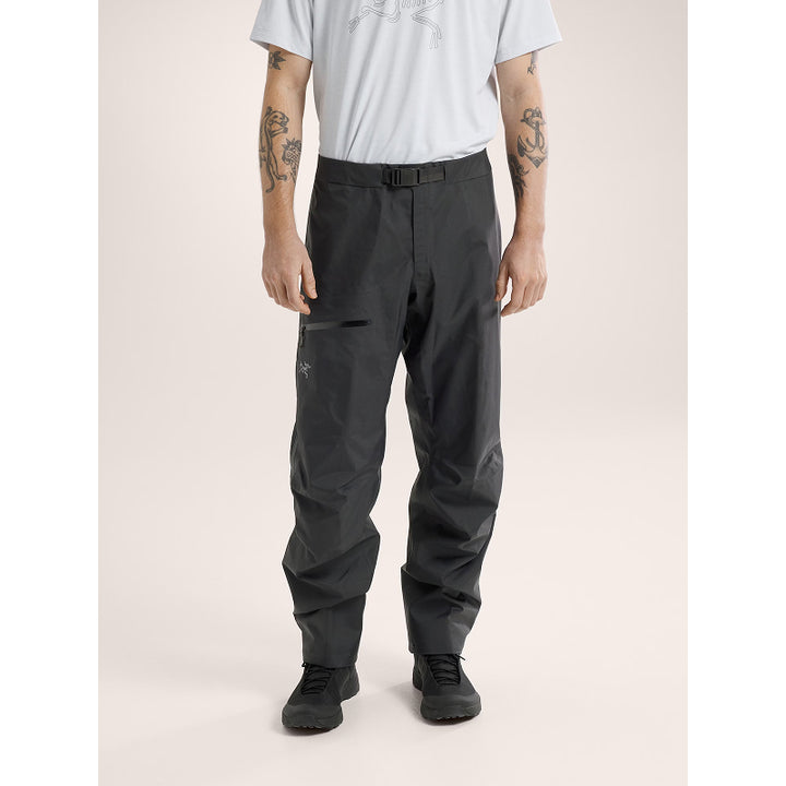 Person wearing black pants on a beige background