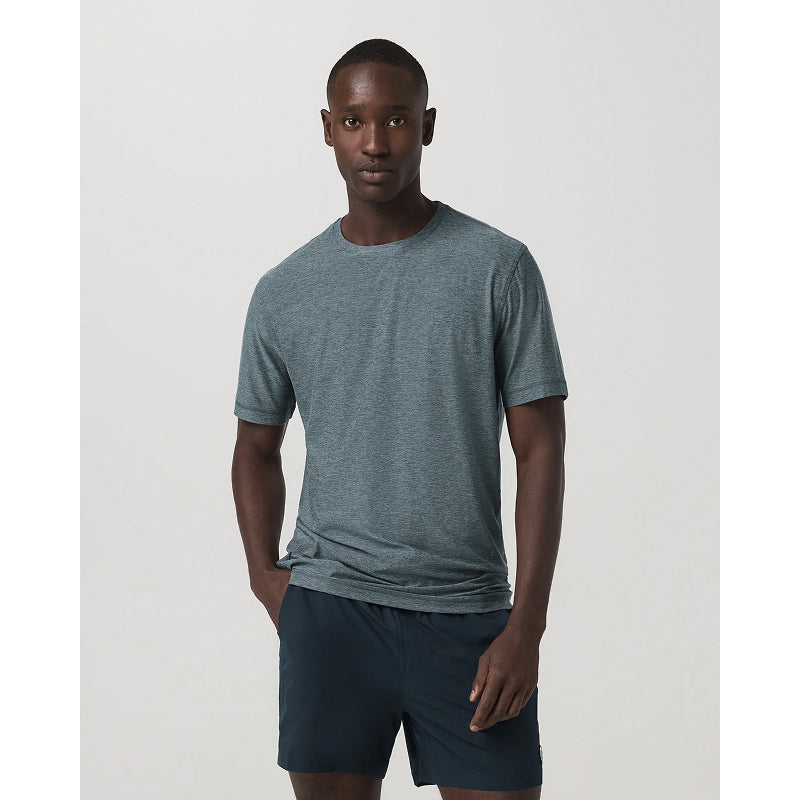 Man wearing a gray t-shirt and navy shorts on a white background