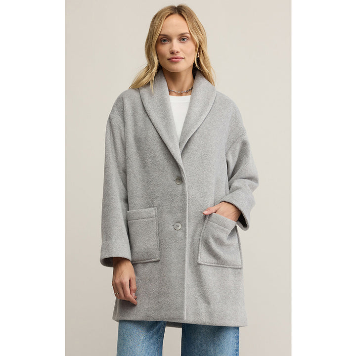 Woman wearing a gray coat on a plain background